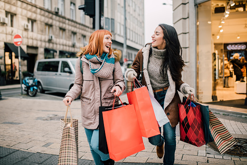 two happy girls with shopping bags