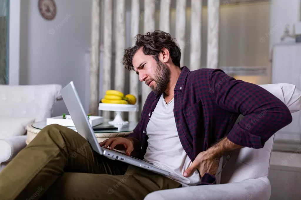 Man sitting while working and having pain